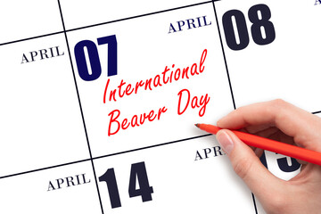 April 7. Hand writing text International Beaver Day on calendar date. Save the date.