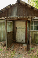 Fototapeta na wymiar Rustic old wooden house in the woods with a small porch and a wooden door.