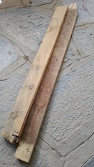 Two old flat wooden planks lying on a stone floor 