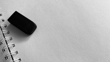 Black and white photo of paper and eraser on table