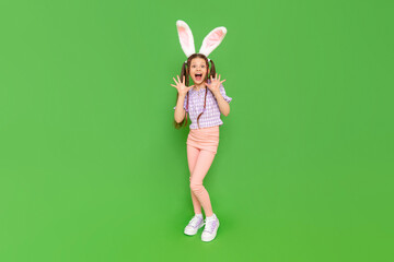 A charming little girl dressed up as an Easter bunny is enjoying the Easter holiday. A full-length...