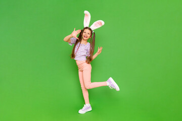 A teenage girl with rabbit ears. A little girl dressed up as an Easter bunny is enjoying a happy...