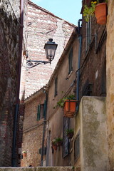 Naklejka premium Chiusdino, Siena, Tuscany, Italy - Typical tuscan historical town with narrow street and terracotta bricks.