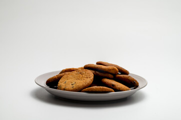 Plate with cookies on white background, a delicious brown food treat