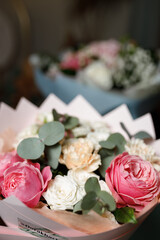 Bouquet of pink peonies and white roses in a pink wrapper