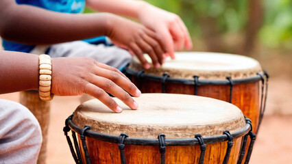 Fototapeta na wymiar Close up of african american girl playing djembe drum outdoors