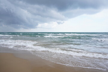 Fototapeta na wymiar Waves of the Mediterranean sea with overhanging threatening clouds