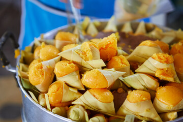 Steamed  Khanom Tarn or toddy palm cake wrapped with palm leaf in pot