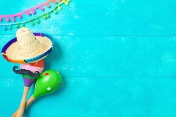 Cinco de Mayo holiday creative greeting card with maracas and mexican sombrero hat on blue wooden background. Top view, flat lay - 783845304