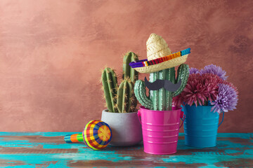 Mexican party concept with cactus and sombrero hat on wooden blue table over wall background. Cinco de Mayo holiday celebration - 783845371
