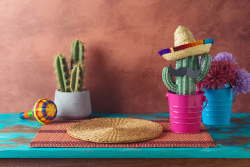 Empty wooden table with place mat  and cactus decoration over wall  background. Mexican party mock up for design and product display - 783845394