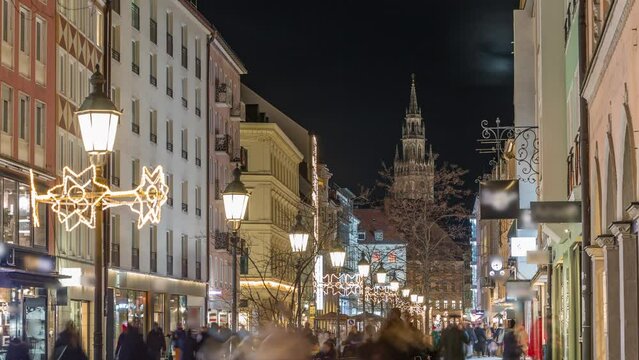 Historic buildings illuminated at the old town of Munich - sendlinger strasse night timelapse. Walking street with benches and streetlights. Glockenspiel on a background. Germany