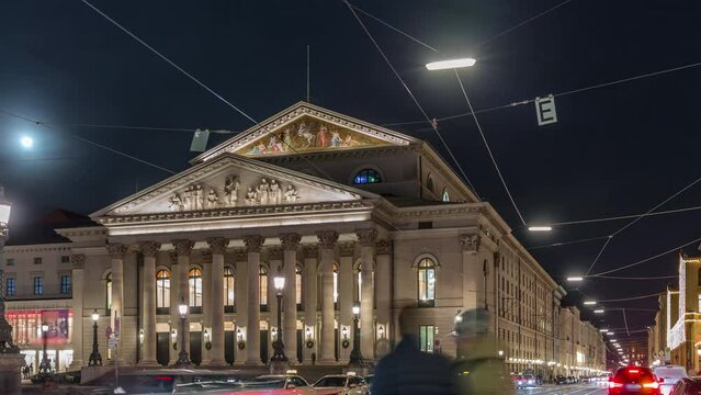 Munich National Theatre or Nationaltheater on the Max Joseph square night timelapse. Traffic on the street with trams and taxi parking. Historic opera house, home of the Bavarian State Opera. Germany