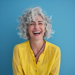 Obraz na płótnie Canvas Joyful Woman with Gray Hair Laughing, Blue Background