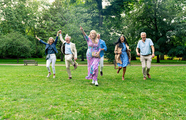 Group of seniors run happy in the park and play together joyful. Old friends spending time together...