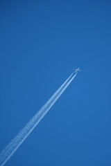 Airplane in the blue sky with contrail