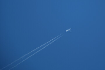 Airplane in the blue sky with contrail