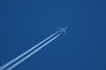 Airplane in the blue sky with contrail