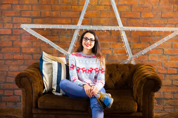 Pretty hipster girl sitting on couch at home