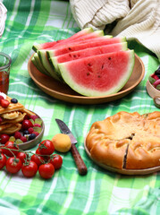 picnic in nature on a checkered blanket with fruit