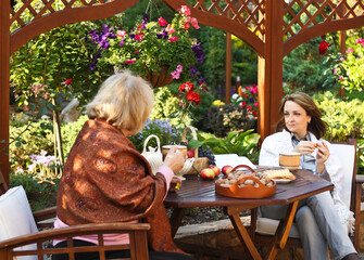 Women drinking coffee in a garden outdoors