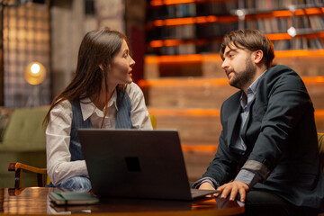 in the recreation area sitting on yellow chairs a businessman makes deal with a female director