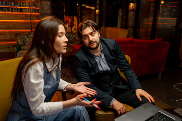 businessman sitting in yellow office chairs makes deal with female director dissatisfied face tense...