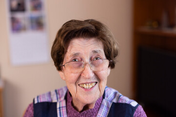 authentisches Portrait einer 90 jährigen Seniorin zuhause im Wohnzimmer