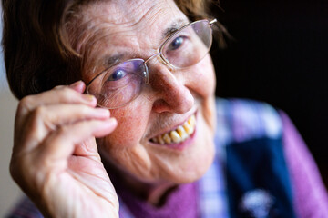 authentisches Portrait einer 90 jährigen Seniorin zuhause im Wohnzimmer