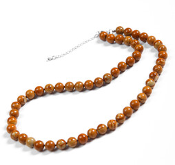 Beads made of natural brown amber on a white background.