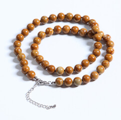 Beads made of natural brown amber on a white background.