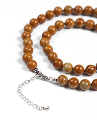 Beads made of natural brown amber on a white background.