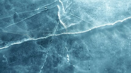 Intricate cracking patterns on an icy surface shot in close-up, showing detailed textures and blue tones