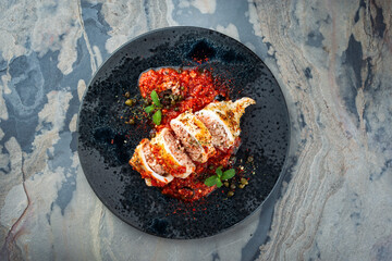 Gebratene Calamari-Tuben mit Reisfüllung in Salsiccia Hackfleisch Tomatensoße serviert als Draufsicht in einer rustikalen Pfanne © HLPhoto