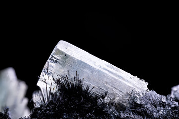 Goshenite (colorless beryl) on schorl from Namibia. macro photography detail texture background....