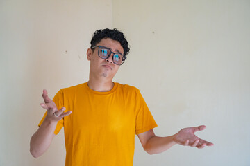 Young man with why pose, asking gesture. The photo is suitable to use for man expression advertising and fashion life style.