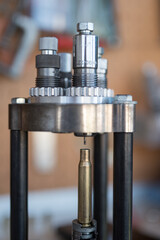Detail of the decapping and resizing process of a 30-06 Springfield or 7.62 x 63 caliber case in the reloading press. To recover its original size and remove the worn primer and replace it with a new