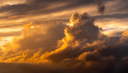 Naklejka na ściany i meble Golden sunlight piercing through dramatic clouds during sunset, creating an ethereal glow.