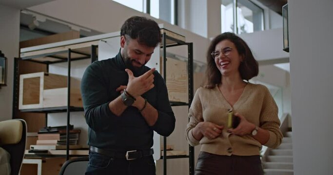 Young colleagues bond during a casual work break in a modern office, fostering a positive and collaborative work environment.