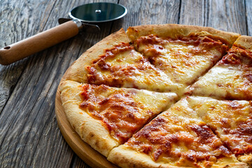 Margherita Pizza with tomato sauce and mozzarella cheese on wooden background
