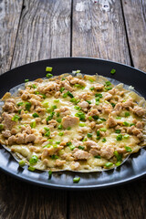 Vietnamese pizza - rice pepper omelet with chicken meat and mushrooms on wooden table
