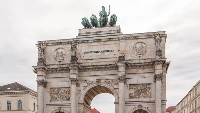The Siegestor or Victory Gate in Munich is a memorial arch, crowned with a statue of Bavaria with a lion quadriga timelapse. Traffic on the street around the monument. Front view. Germany