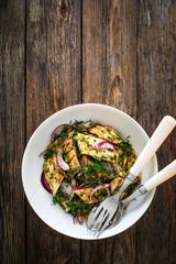 Marinated herring fillets with dill and red onion on wooden table

