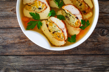 Baked stuffed turkey sliced fillet in jelly and vegetables on wooden table
