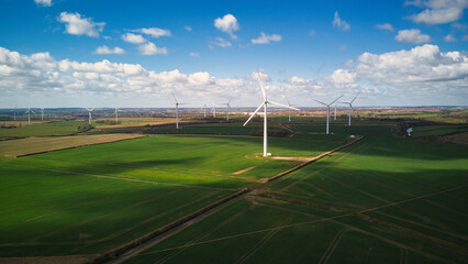 Turbine Windmills wind farm in rural England. Renewable energy. Beautiful sunny day.