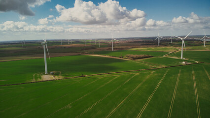 Obraz premium Turbine Windmills wind farm in rural England. Renewable energy. Beautiful sunny day. 