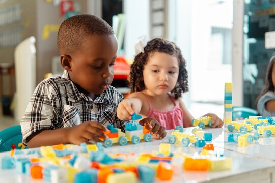 Couple of little chlidren friends playing in a kindergarten.