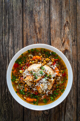 Fresh vegetable soup with lentil on wooden table
