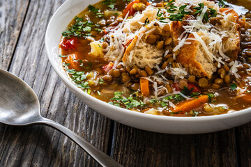 Fresh vegetable soup with lentil on wooden table
