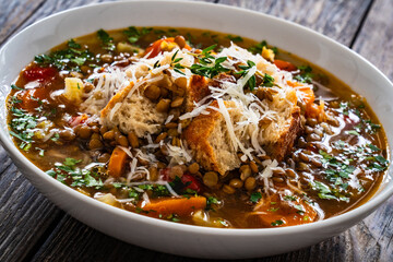 Fresh vegetable soup with lentil on wooden table
